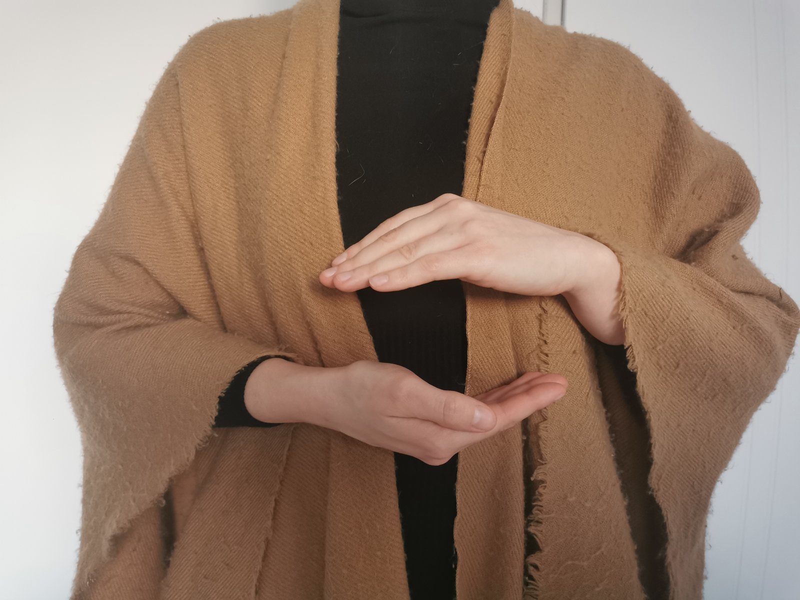 Gros plan de mains positionnées pour un soin énergétique. Les mains sont ouvertes l'une vers l'autre, comme pour canaliser l'énergie.