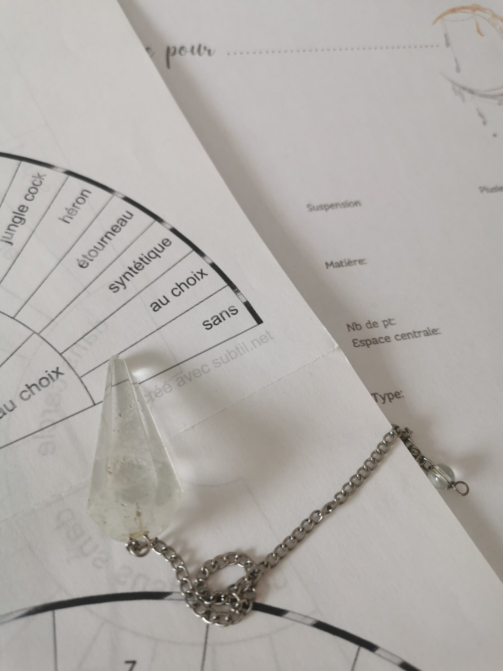 Illustration d'une étude vibratoire avec un pendule au-dessus d'un cadran. Texte expliquant le processus de connexion pour sélectionner les couleurs, les matières et les énergies qui soutiendront le chemin actuel du client.