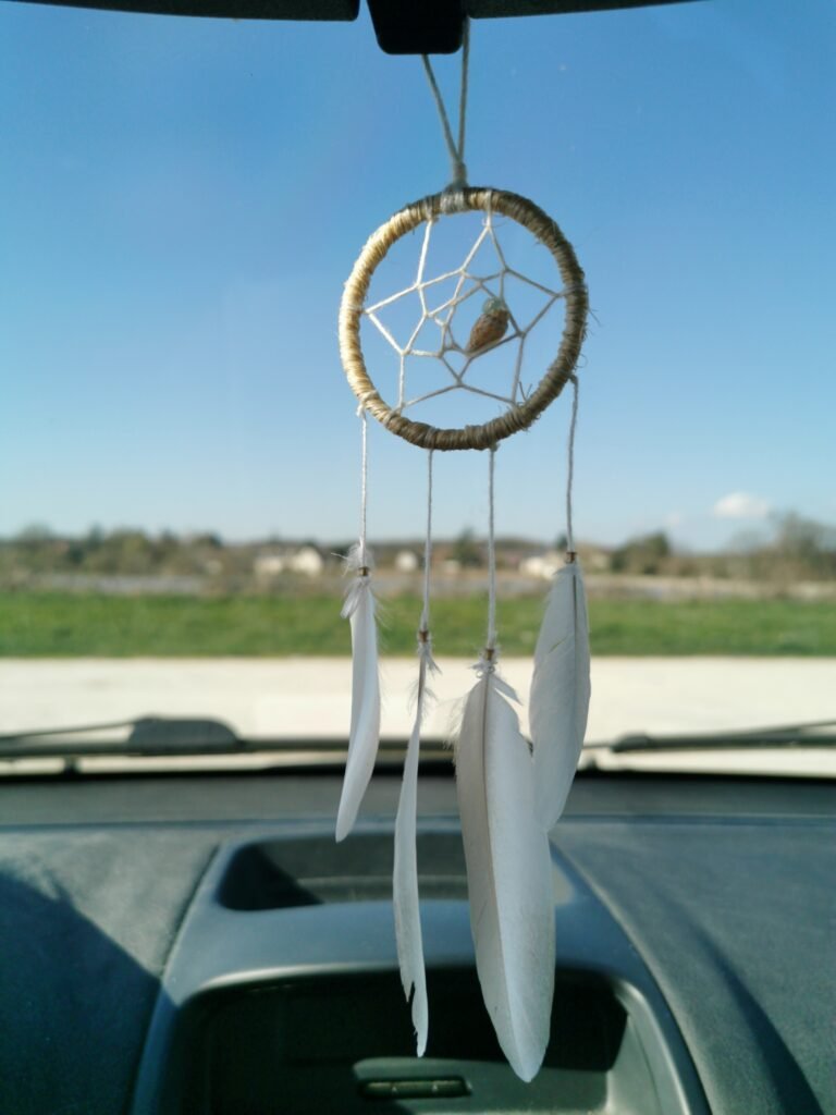 Attrape-rêves artisanal style bord de mer avec cercle en corde naturelle, coquillage central et plumes de mouette.