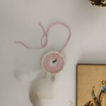 Parure Nomade rose poudré et écru avec plumes de canard blanches.