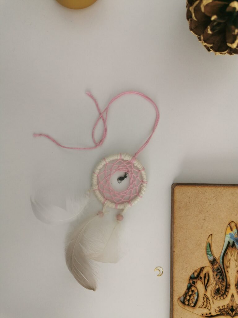 Parure Nomade rose poudré et écru avec plumes de canard blanches.