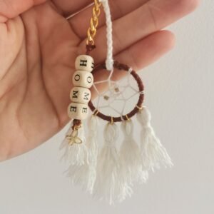 Porte-clé Votum Compagnon Nomade avec perles en bois mot HOME et pompons blancs.