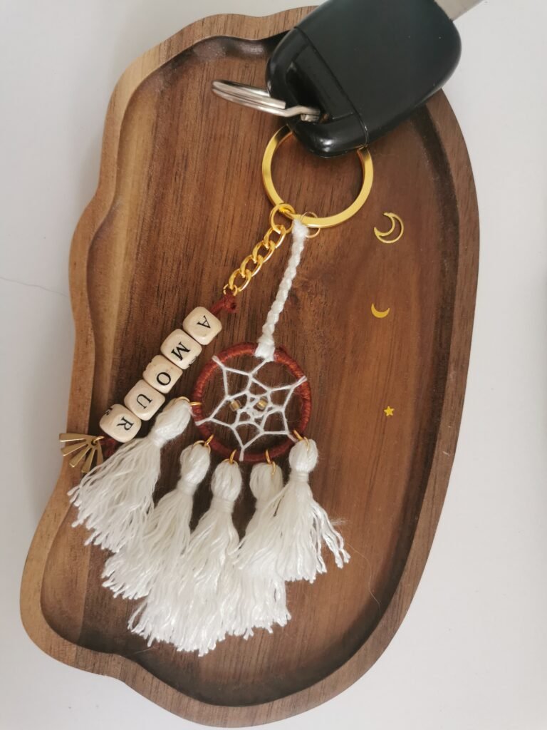 Porte-clé Votum Compagnon Nomade avec perles en bois mot Amour et pompons blancs.