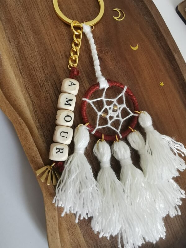 Porte-clé Votum Compagnon Nomade avec perles en bois mot Amour et pompons blancs.