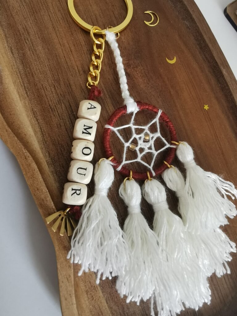 Porte-clé Votum Compagnon Nomade avec perles en bois mot Amour et pompons blancs.