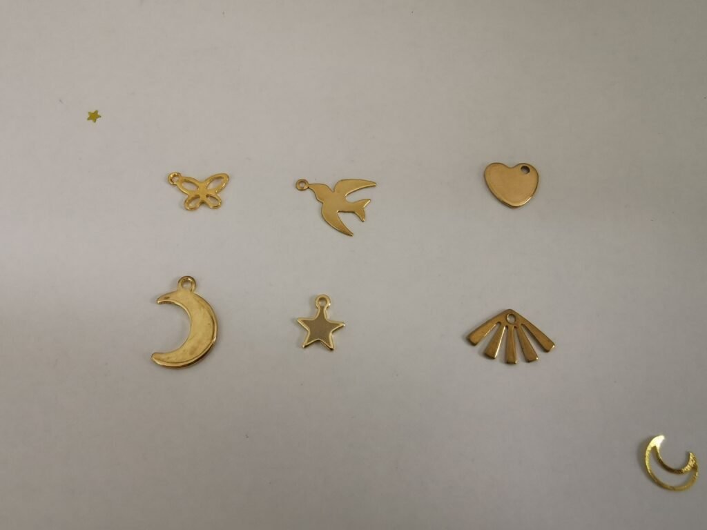 Assortiment de breloques dorées pour attrape-rêves : papillon ajouré, hirondelle en vol, cœur plein, croissant de lune, étoile à cinq branches et éventail rayonnant