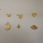 Assortiment de breloques dorées pour attrape-rêves : papillon ajouré, hirondelle en vol, cœur plein, croissant de lune, étoile à cinq branches et éventail rayonnant