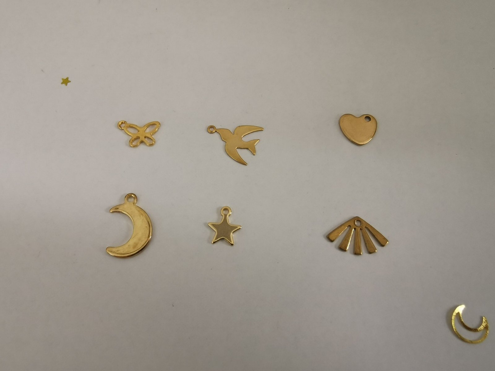 Assortiment de breloques dorées pour attrape-rêves : papillon ajouré, hirondelle en vol, cœur plein, croissant de lune, étoile à cinq branches et éventail rayonnant