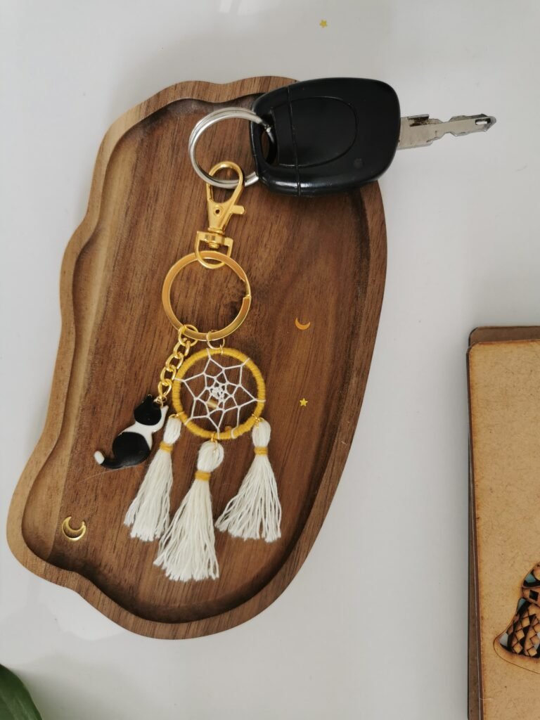 Porte-clés attrape-rêves curry et blanc ,, pompons blanc et breloque chat sur socle en bois.