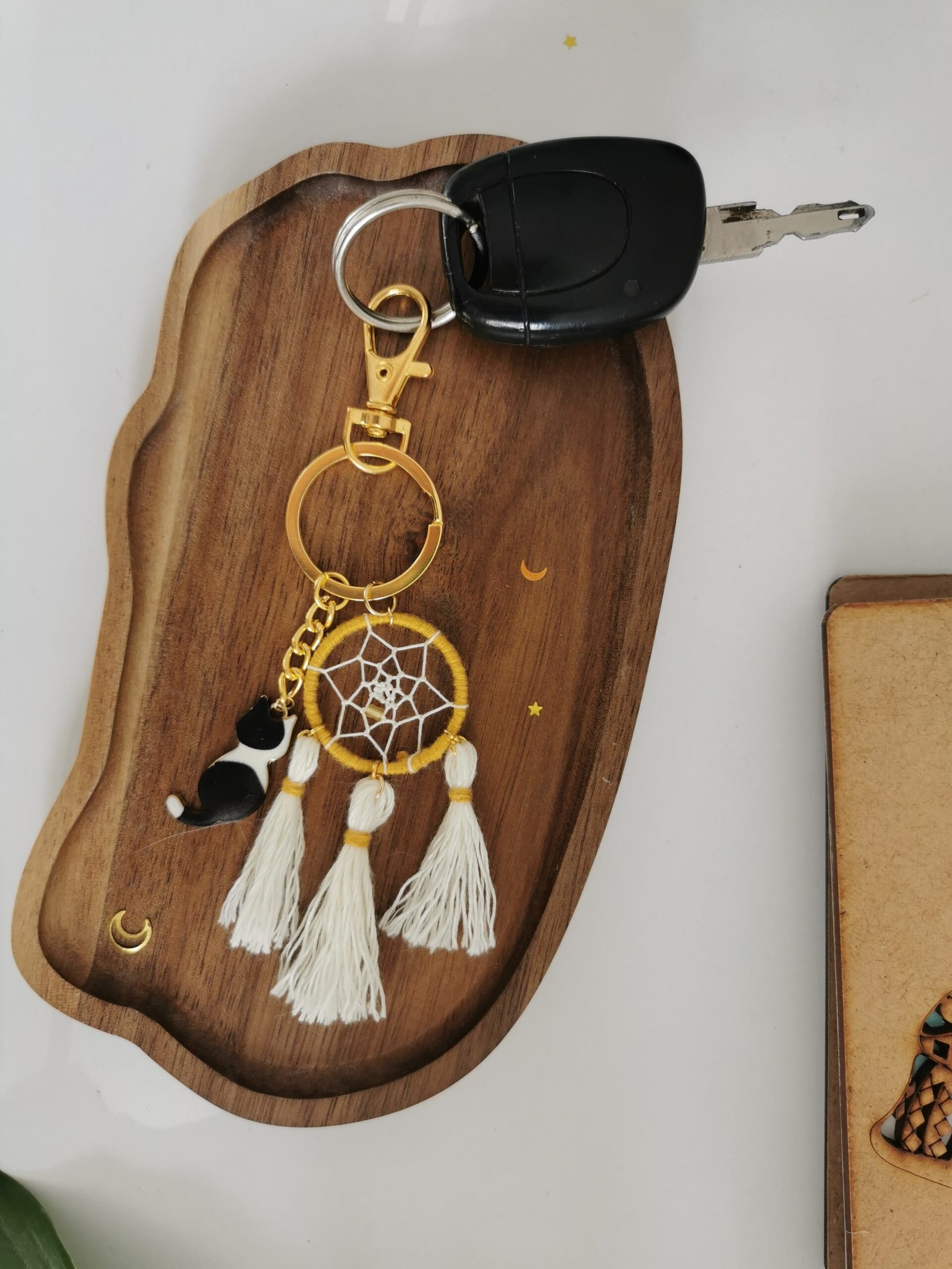 Porte-clés attrape-rêves curry et blanc ,, pompons blanc et breloque chat sur socle en bois.