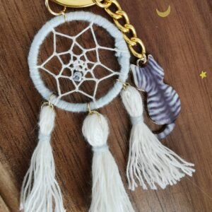 Porte-clés Felis Prospicio sur bois : mini attrape-rêve blanc, pompons et breloque chat tigré gris.