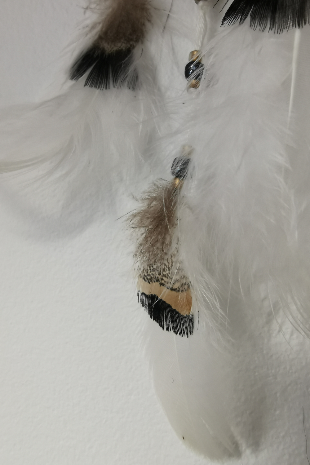 Plumes naturelles de finition de faisan (2 cm) et duvet de poule blanc suspendues sous l'attrape-rêves de voiture "Zéphyr".