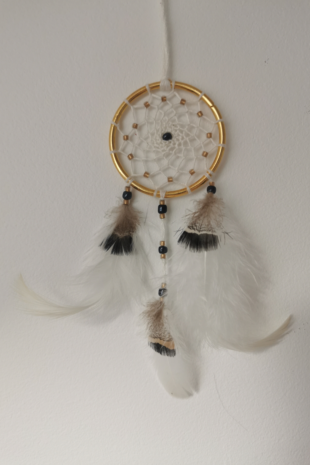 Petit attrape-rêves de rétroviseur élégant "Zéphyr" de 5 cm, fait main par Yudreami, avec un anneau doré et un tissage en fil de bambou crème.